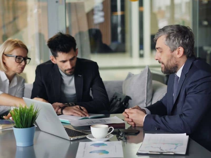 Buyer and lender discussing property documents during a commercial real estate transaction requiring an ALTA survey