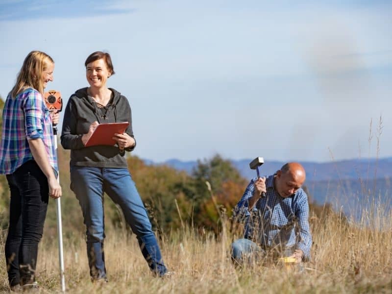 Licensed surveyors locating and setting a boundary marker to help determine property lines
