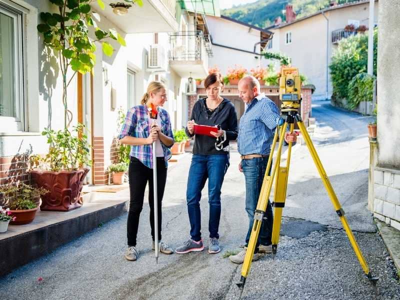 Property owner meeting with a land surveyor to discuss survey details before signing a contract.