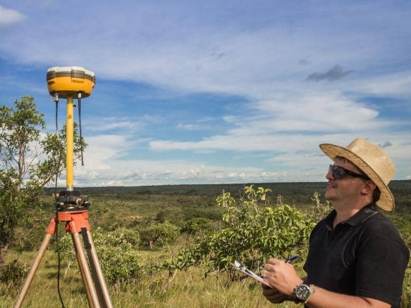 Licensed land surveyor using GPS equipment to collect measurements during field work